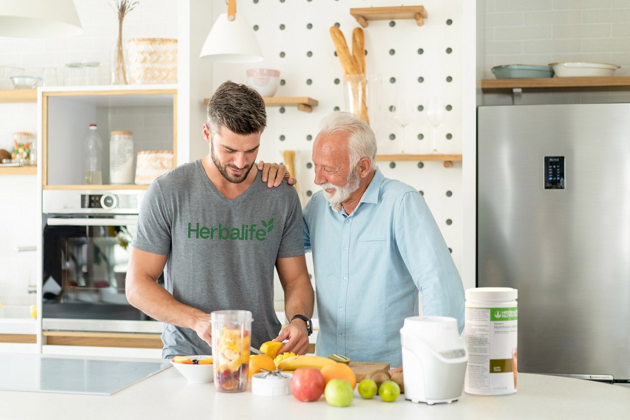 Two men making an Herbalife Formula 1 shake at home Father and son making an Herbalife Formula 1 protein shake in the kitchen.