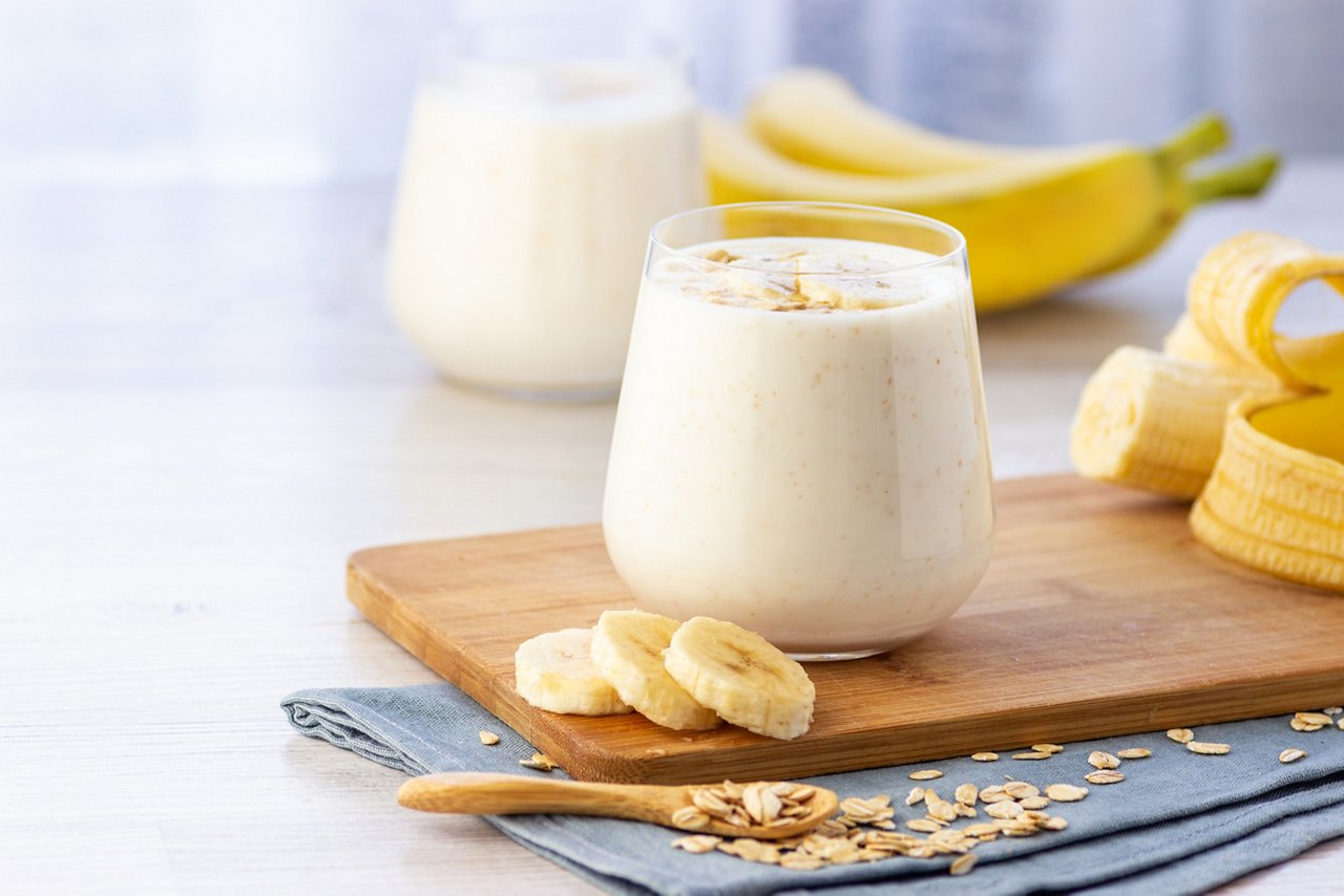 Protein Shake with Banana and Oatmeal A protein shake made with banana and oatmeal on a cutting board